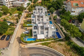 A modern multi-story residential building with a rooftop pool and solar panels. - Villa Sapphire with Heated Pool (Malinska)