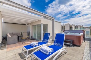 A rooftop terrace with two blue lounge chairs, a hot tub, and a covered seating area with a sofa and table. - Villa Sapphire with Heated Pool (Malinska)