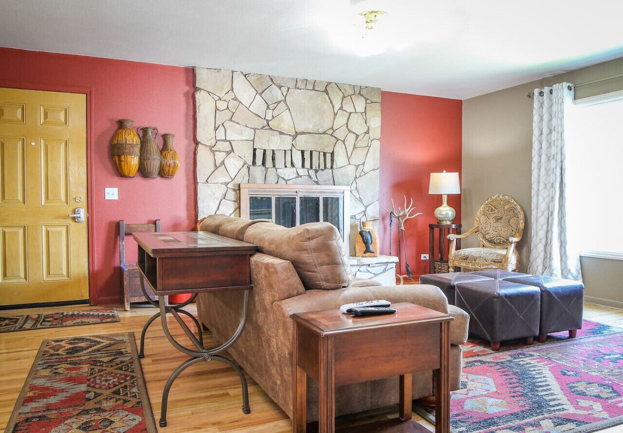 Cozy living room with original hardwood floors, a large picture window, wood burning fireplace and a comfortable couch - great for relaxing!