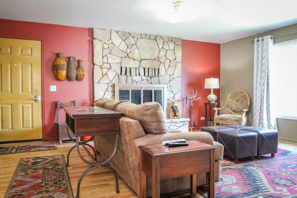 Cozy living room with original hardwood floors, a large picture window, wood burning fireplace and a comfortable couch - great for relaxing!