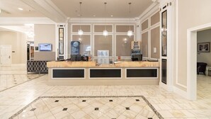 A reception area with a marble floor, a reception desk, and a large window.