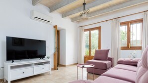 Un salon avec un téléviseur, un canapé et une petite table.