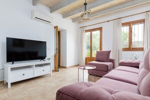 A living room with a TV, sofa, and a small table.
