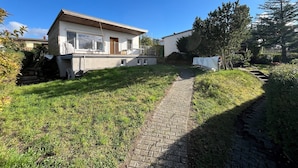 Een woonhuis met een geplaveid pad dat naar een balkon leidt.