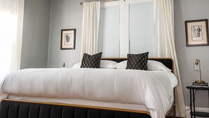 Une chambre à coucher avec un grand lit, un lustre et une table de chevet.