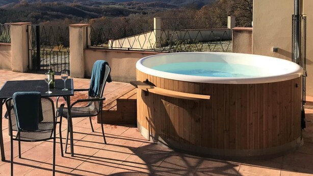 Un jacuzzi en un patio con vista a la montaña.