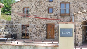 Un edificio de piedra con un letrero que dice "LE MAS".