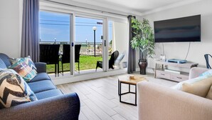 A modern living room with a sofa, a coffee table, and a TV mounted on the wall.