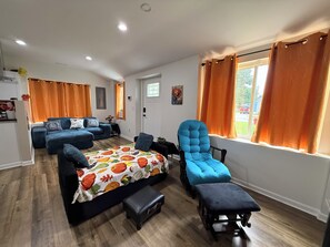 Une pièce spacieuse avec un grand lit, un fauteuil bleu et un canapé.