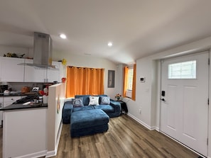 A compact living space with a kitchenette, a sofa set, and a door with a window. - Gingers Great Lakes Popsicle  😄 near Great Lakes min drive!  (Port Huron)
