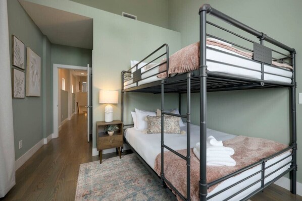 A bunk bed room with a nightstand, a lamp, and a rug.