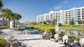 Relax on the beach with lounge chairs and enjoy the view of the adjacent building complex.