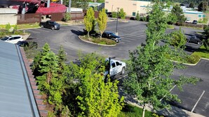 A parking lot with several vehicles, a water park with red and yellow slides, and a building with a green roof in the background.