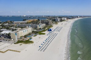 Un hôtel situé en bord de mer, composé de plusieurs bâtiments, avec une plage de sable fin et une vue dégagée sur l’océan.