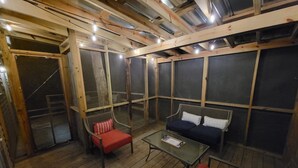 A cozy room with a wooden floor, a glass table, and two red chairs. - Blue Ridge Mountain Cottage~1 minute from Parkway! (Newland)