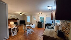 A compact kitchen with a dining area, a fireplace, and a TV. - Blue Ridge Mountain Cottage~1 minute from Parkway! (Newland)