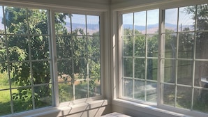 A room with large windows, a bench, and a view of greenery outside. - Oliver Country House in the Wine Capital of Canada (Oliver)