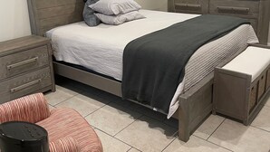 Ein Schlafzimmer mit einem Bett, Nachttischen, einem Schminktisch und einem kleinen Stuhl.