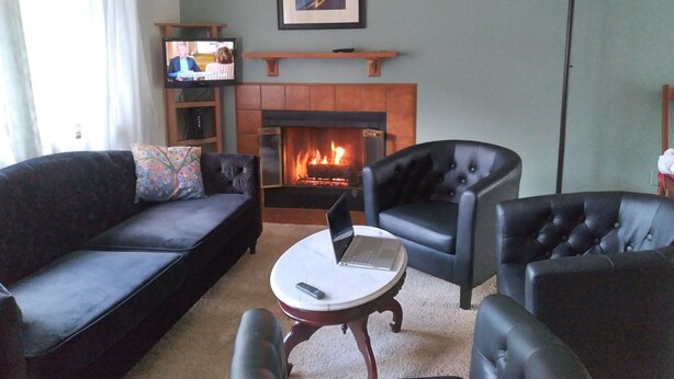 A living room with a fireplace, a television, and a laptop on a table. - "Almost Heaven" Palmer Lake, CO (#STR0419522) (Palmer Lake)