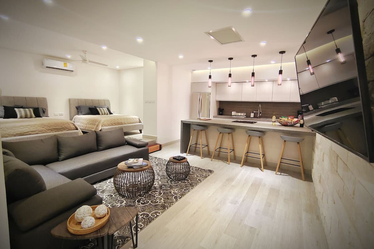 Moderni huoneisto, jossa on olohuone, pieni keittiö ja ruokailutila.