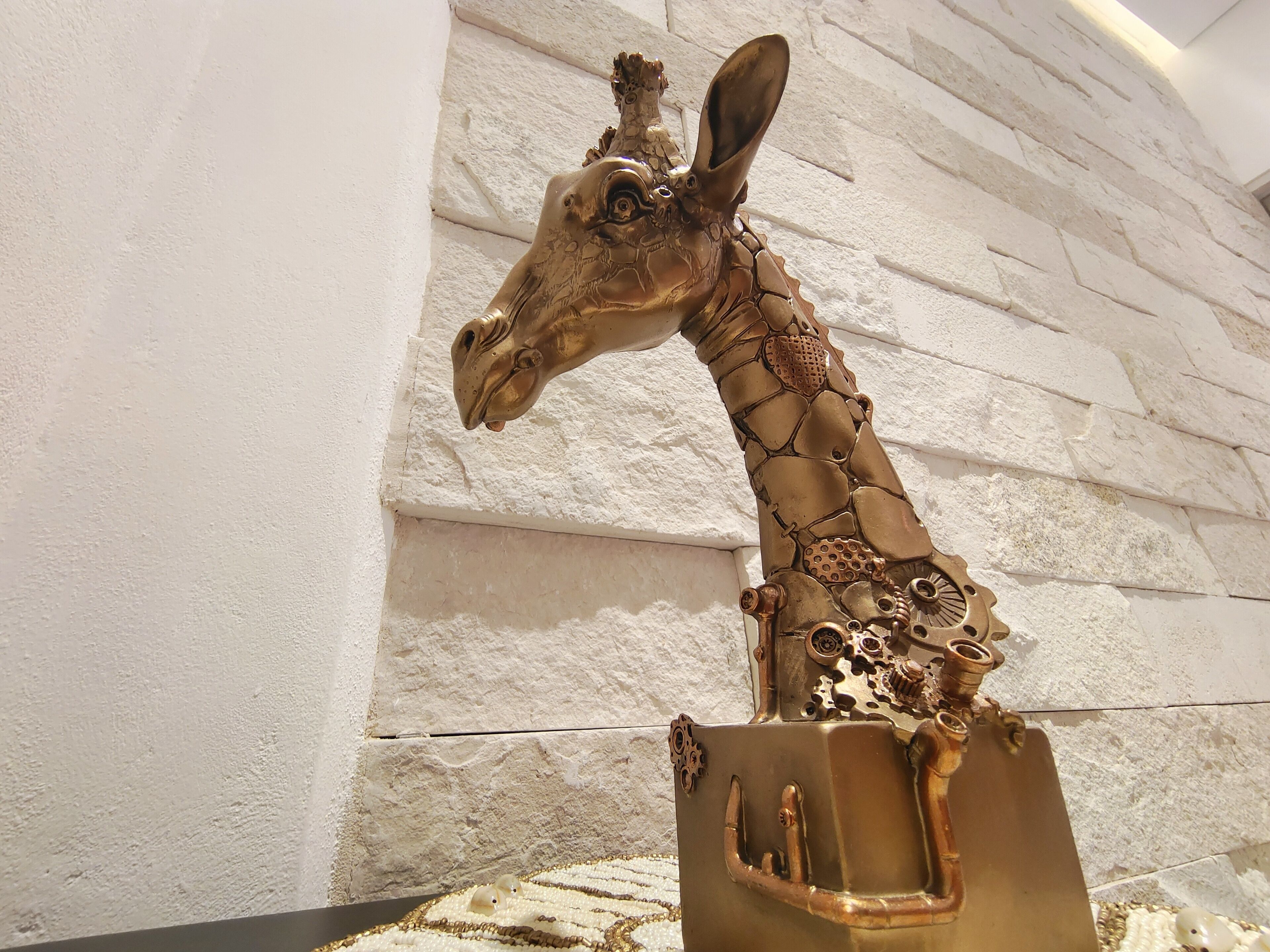 Una escultura de jirafa con detalles intrincados y acabado metálico.