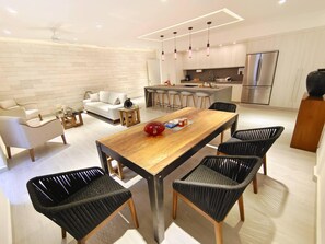 A modern kitchen with a central island, stainless steel appliances, and pendant lighting. - 1st Luxury Warehouse (Cancun)