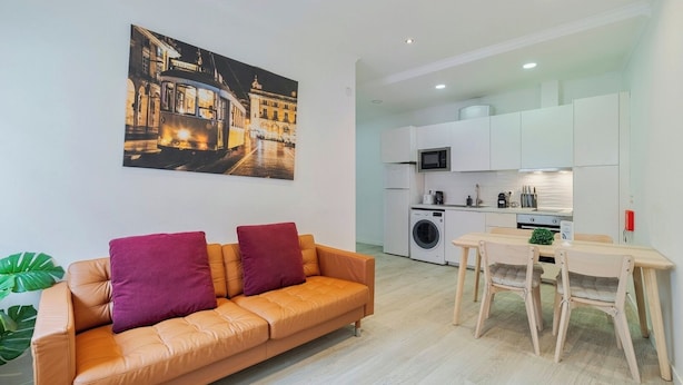 Ein modernes Apartment mit einer Couch, einem Esstisch, einer Küche und einem großen Stadtbild.