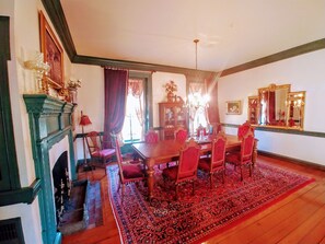 A dining room with a wooden table, red upholstered chairs, a chandelier, and a large mirror on the wall. - Chanceford Hall Bed & Breakfast (Snow Hill)