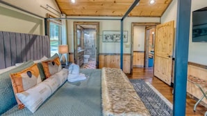Une chambre à coucher avec un lit, des oreillers, un tapis et un plafond en bois.