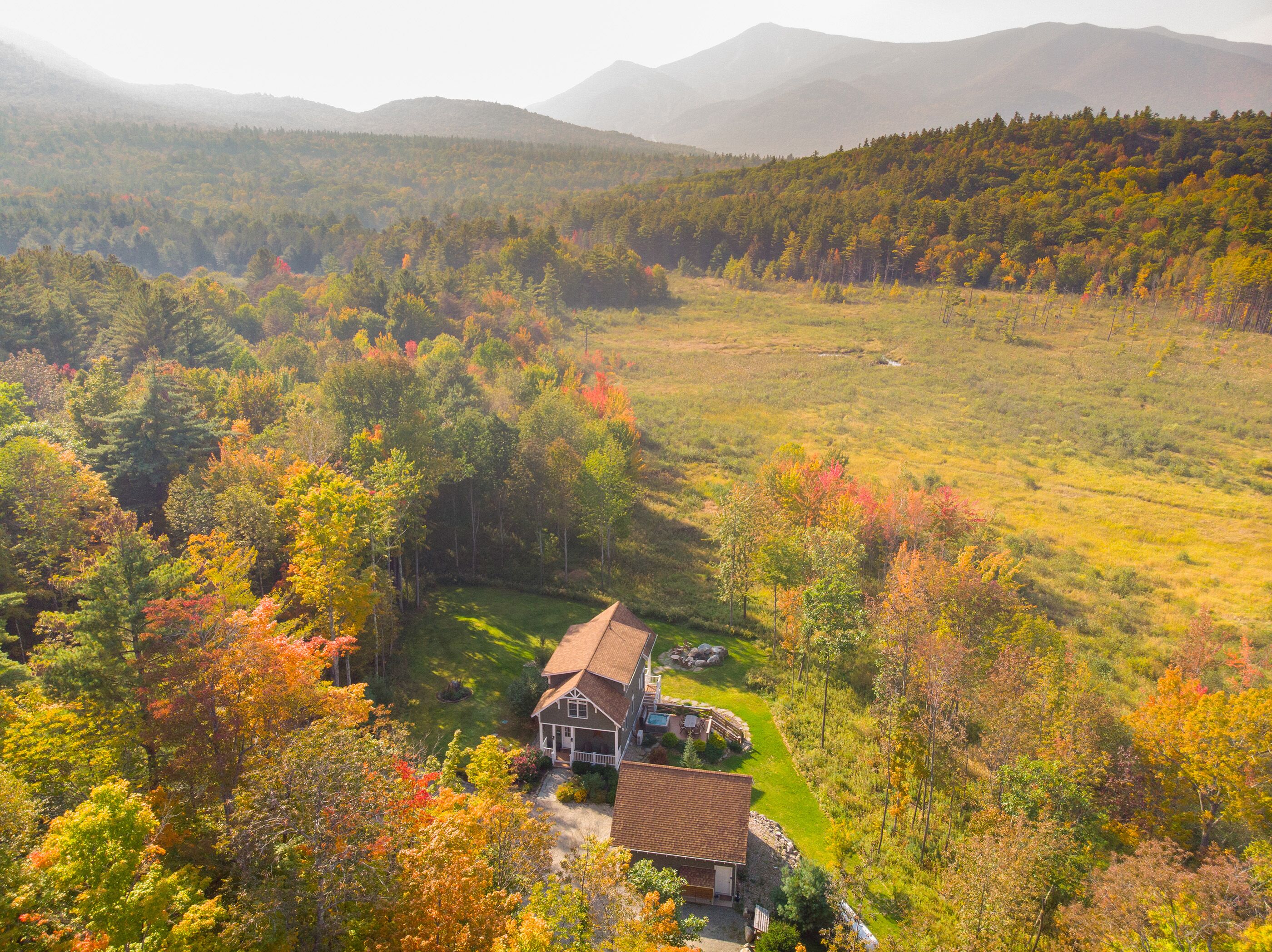 Una casa rodeada por un bosque de follaje otoñal.