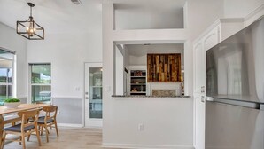 Eine moderne Küche mit einem Edelstahlkühlschrank, einem Holzessttisch und Stühlen.