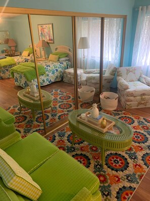 Relax in this stylish living room with a large mirror, comfortable armchairs, and a floral-patterned sofa.