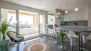 A modern kitchen with a large island, bar stools, and a view of the city.