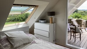 Un dormitorio con cama, escritorio y vistas al exterior.
