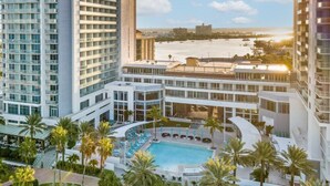 A high-rise hotel with a pool area, palm trees, and a view of the beach. - Wyndham Clearwater Beach Resort - 4 Bedroom (Clearwater Beach)