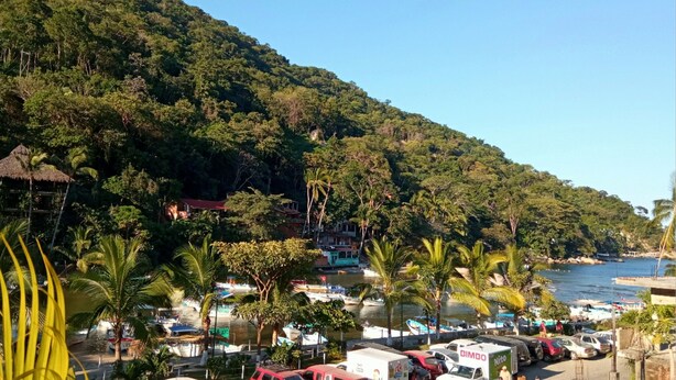 A coastal area with a dock, parked vehicles, and a hillside with dense vegetation. - WATER VIEWS! Luxury Boho In-Village Apt #3 (Boca de Tomatlán)