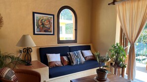 A cozy living room with a sofa, a lamp, a coffee table, and potted plants. - WATER VIEWS! Luxury Boho In-Village Apt #3 (Boca de Tomatlán)