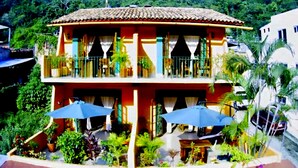 A two-story building with a balcony, outdoor seating area, and potted plants. - WATER VIEWS! Luxury Boho In-Village Apt #3 (Boca de Tomatlán)