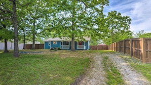 A backyard with a blue house, a wooden fence, and a gravel path. - Table Rock Lake Retreat < 1 Mi to Boat Launch (Golden)