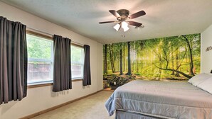 A bedroom with a bed, a ceiling fan, and a forest mural on the wall. - Table Rock Lake Retreat < 1 Mi to Boat Launch (Golden)