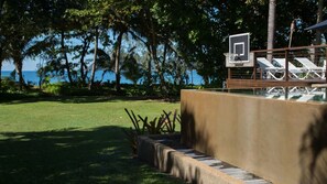 Area piscina con canestro da basket, lettini e vista sul mare.