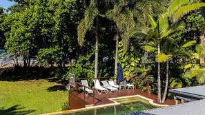 Area piscina con sedie a sdraio e canestro da basket.