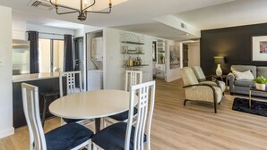 Ein modernes Wohnzimmer mit Essbereich, einer Couch und einer Chandelier.