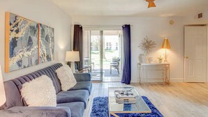 Ein modernes Wohnzimmer mit einem grauen Sofa, einem Couchtisch und einem Bild an der Wand.