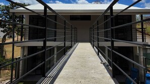 A modern building with a concrete pathway leading to a covered entrance. - Relax beach house at 10 min from the best beaches in Costa Rica (Provincia de Guanacaste)