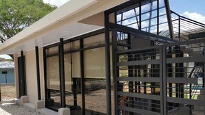 A modern building with large glass windows and a metal gate. - Relax beach house at 10 min from the best beaches in Costa Rica (Provincia de Guanacaste)