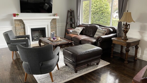 A living room with a fireplace, leather sofa, armchairs, and a television. - Spacious 4 Bedroom House in Quiet Neighborhood, near Light Rail (Seattle)
