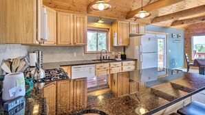 A kitchen with wooden cabinets, a stove, a dishwasher, and a refrigerator.