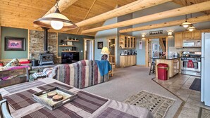 A cozy living room with a fireplace, a dining area with a wooden table, and a kitchen with modern appliances.