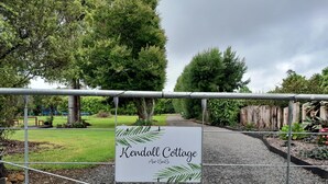 Ein begrenzter Zugang zum Kendall Cottage mit einem Schild.